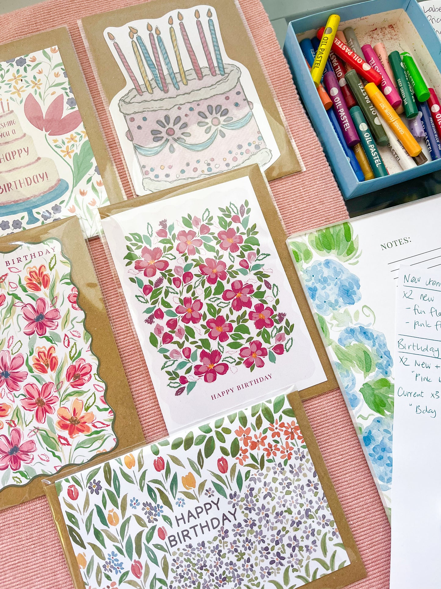 Collection of birthday cards with colorful designs on a table with crayons.