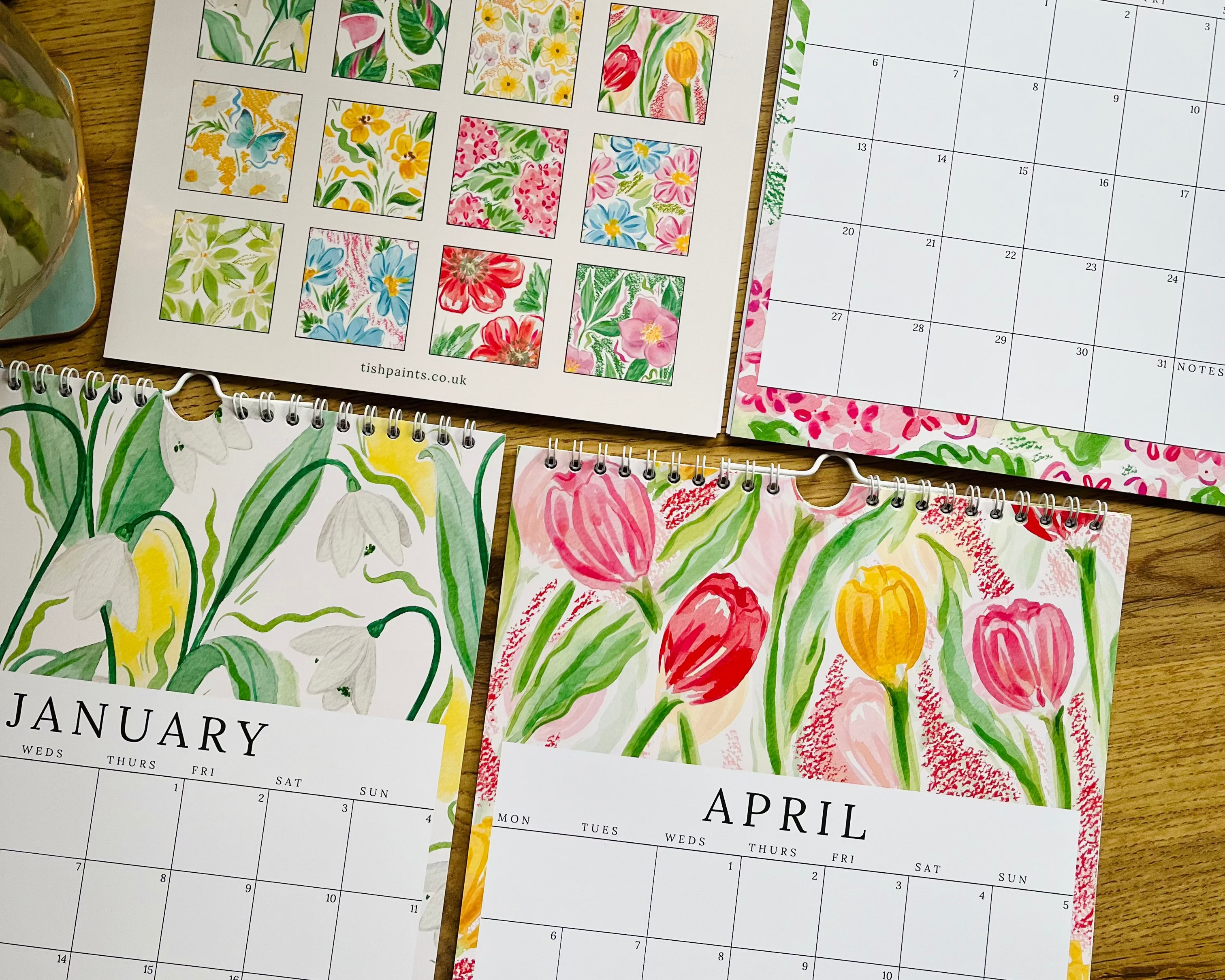 Floral-themed calendar pages for January, April, and July on a wooden surface.